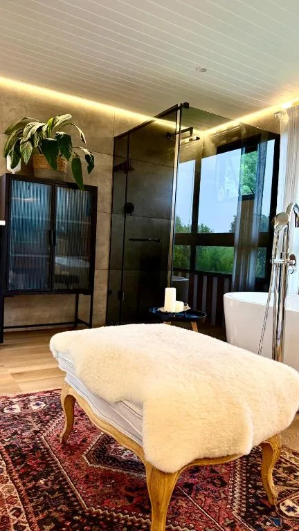 Modern bathroom with walk-in shower, freestanding tub, and scenic garden views