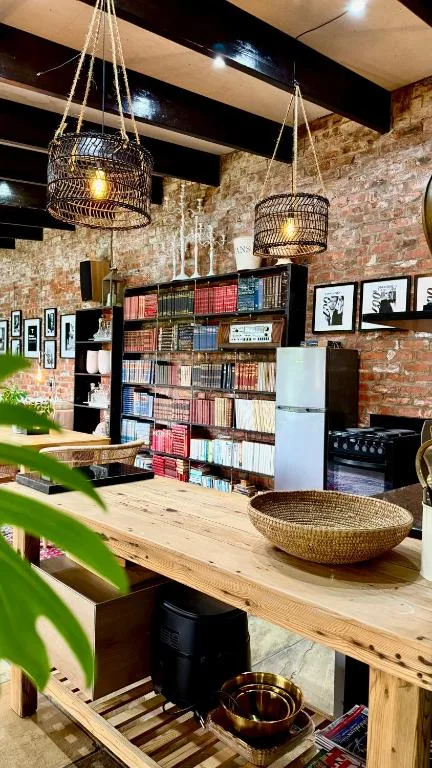 Open-plan lounge with exposed brick walls, wooden counter, and pendant lighting