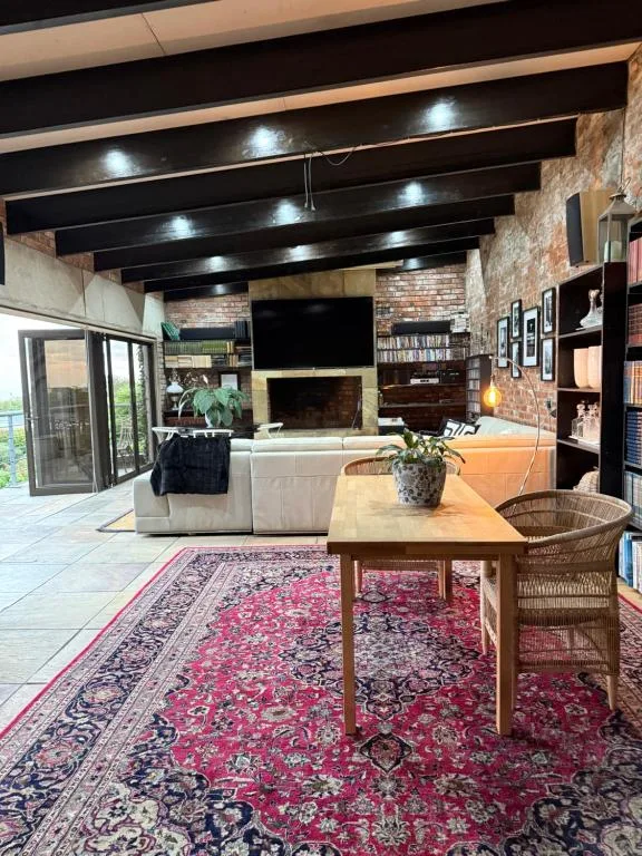 Modern loft living room with fireplace, sofa, and exposed beam ceiling