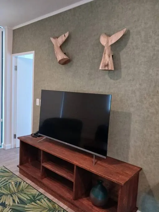 Living room with flat-screen TV on wooden stand and wall art