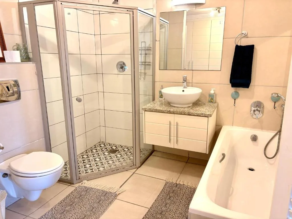 Modern bathroom with shower, toilet, basin, and bathtub fixtures
