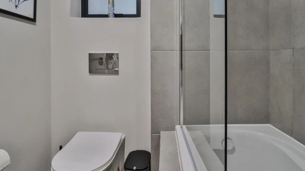 Modern bathroom with toilet, shower enclosure, and tiled walls