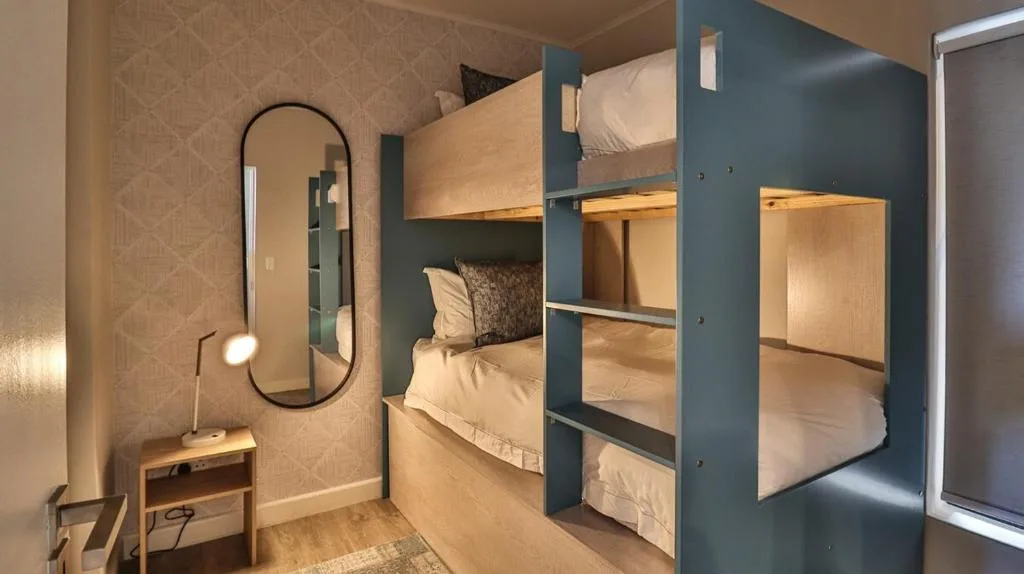 Modern bedroom with built-in bunk beds and arched mirror wall decor