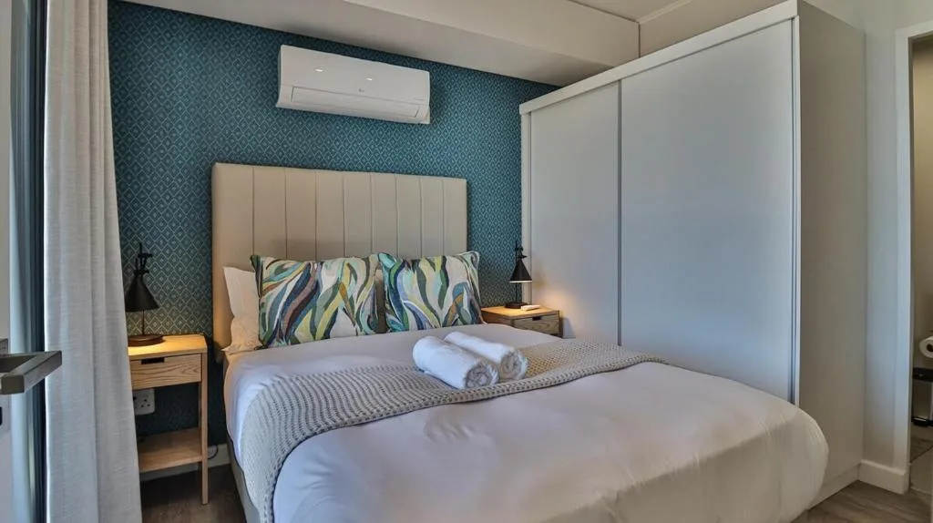 Modern bedroom with upholstered bed, patterned headboard, and air conditioning unit