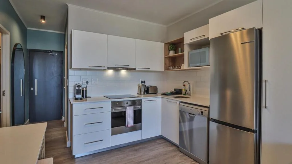 Modern kitchen with white cabinetry, stainless steel appliances, and built-in oven