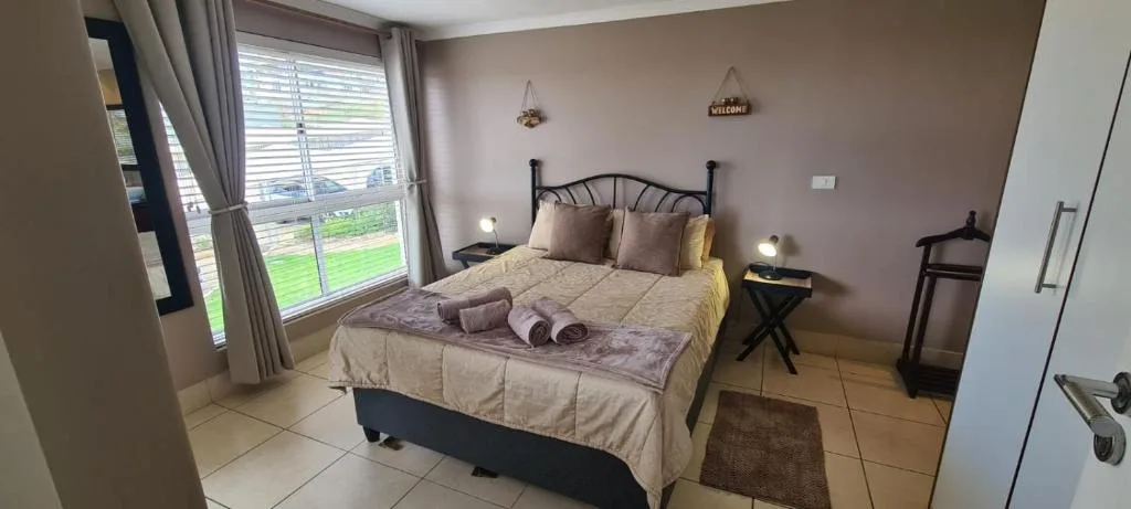 Spacious bedroom with double bed, garden views through large windows