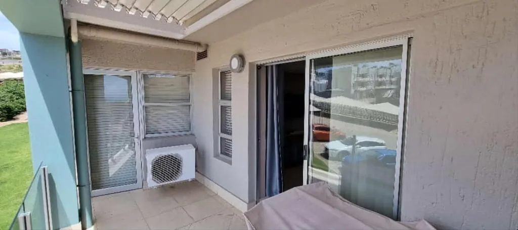 Covered patio area with sliding glass doors and ocean views beyond