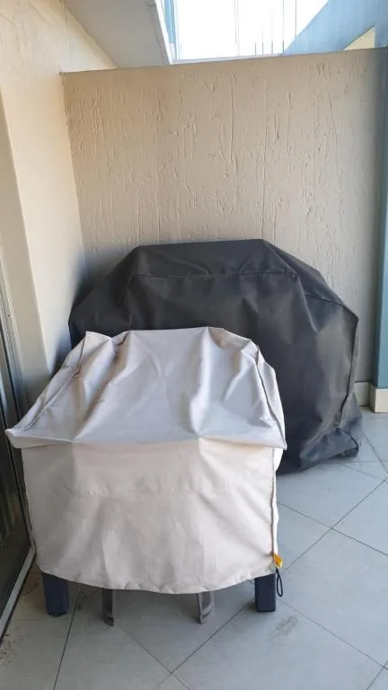 Covered braai grill stored in sheltered outdoor corner space