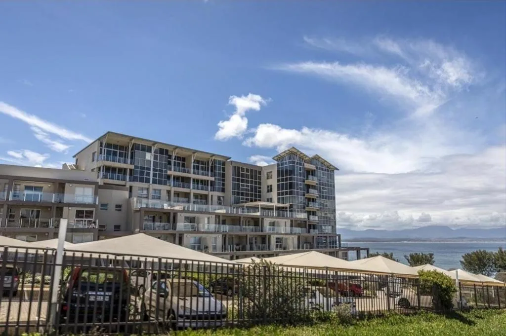 Modern multi-story beachfront apartment complex with ocean views and shaded deck areas