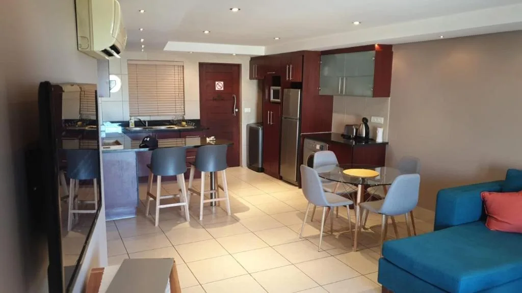 Modern kitchen with burgundy cabinetry, stainless steel appliances, and dining area