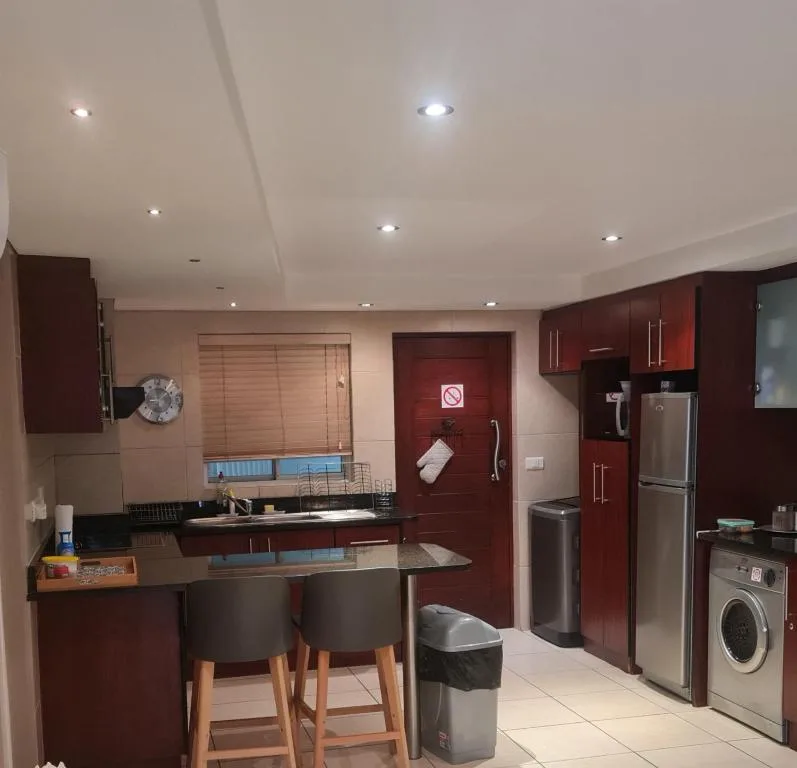 Modern kitchen with burgundy cabinetry, stainless steel appliances, and breakfast bar seating