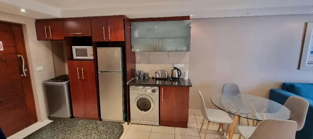 Modern kitchen with red cabinetry, stainless steel appliances, and washing machine
