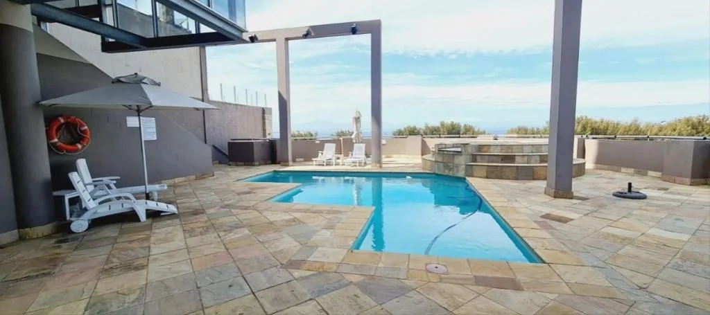 Swimming pool on elevated deck with ocean and mountain views beyond