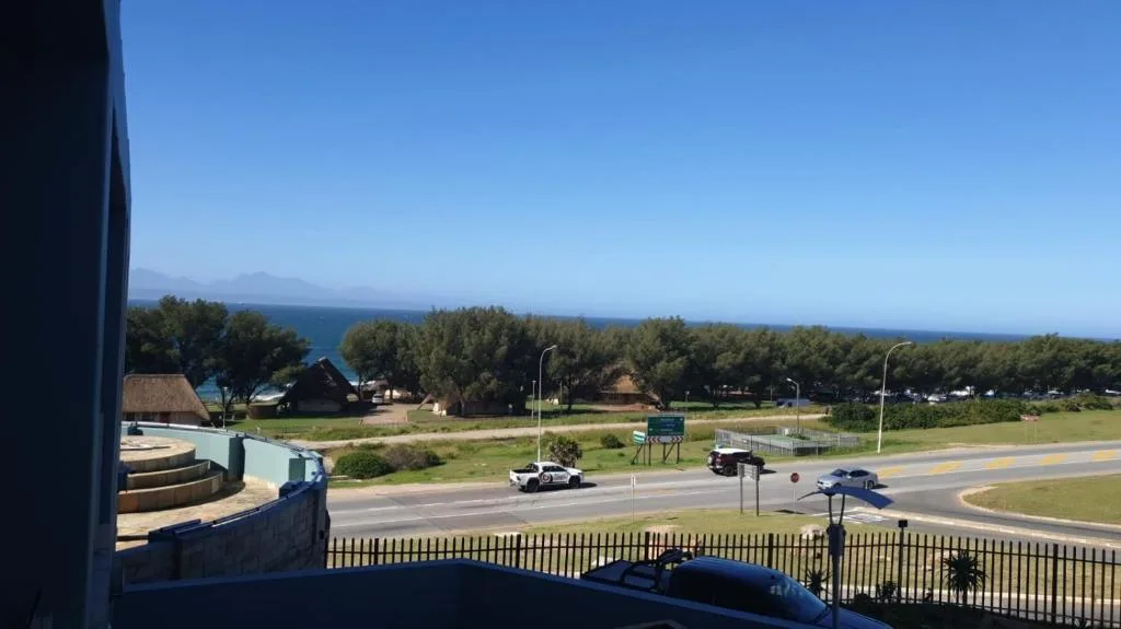 Ocean and coastal landscape visible beyond tree-lined garden route grounds