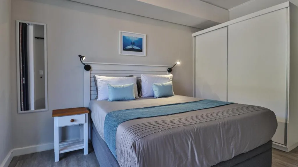Modern bedroom with queen bed, blue accents, and built-in wardrobes
