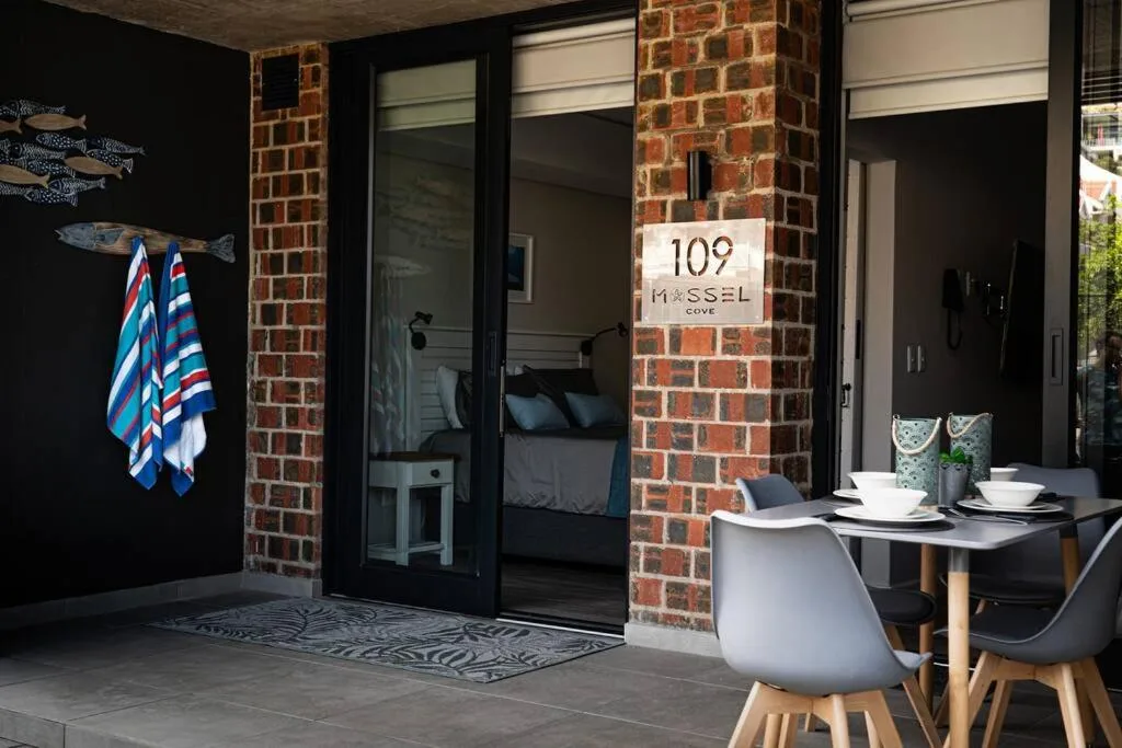 Outdoor patio with dining table and brick building entrance