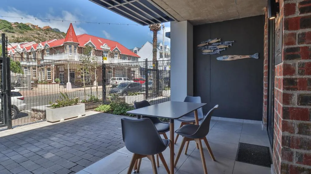 Covered patio with dining table overlooking historic Mossel Bay town architecture
