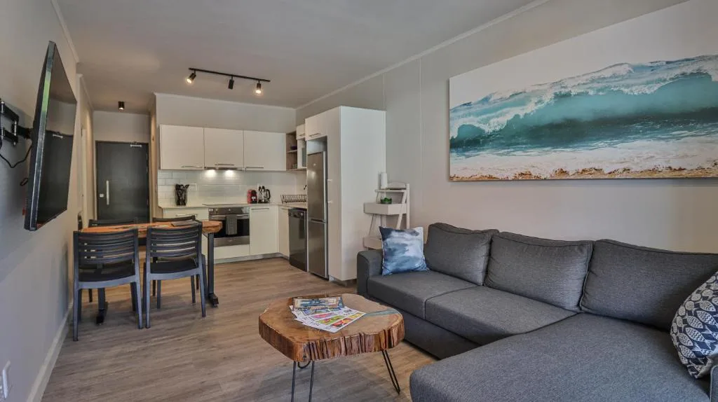 Open-plan lounge with gray sofa and ocean wave artwork on wall