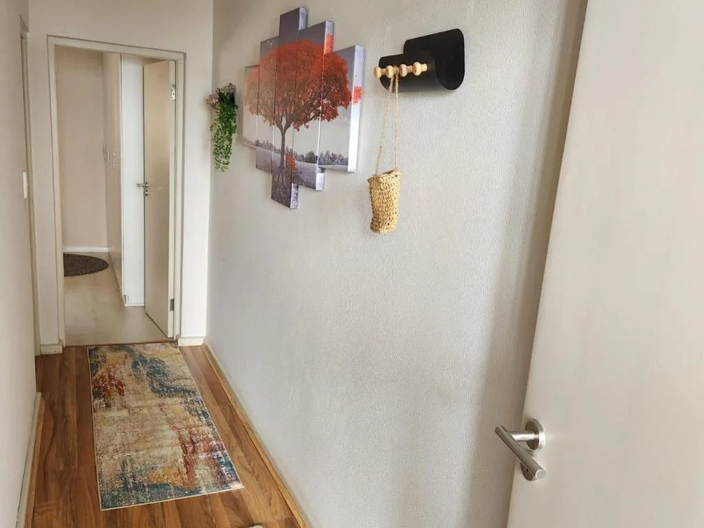 Hallway with framed tree artwork and decorative wall hangings