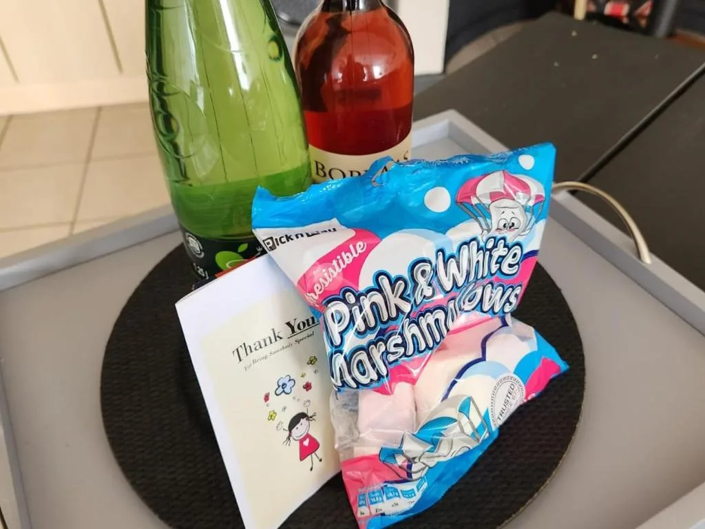 Welcome amenities including marshmallows, beverages, and thank you card on table