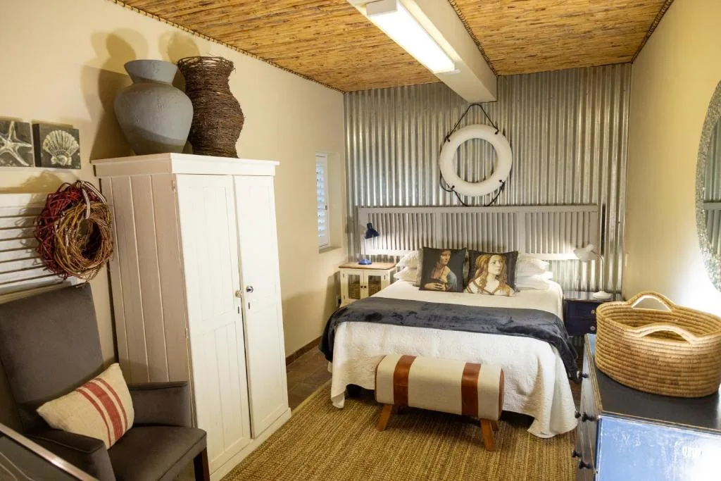 Cozy bedroom with bed, wooden ceiling, corrugated metal accent wall, rustic decor