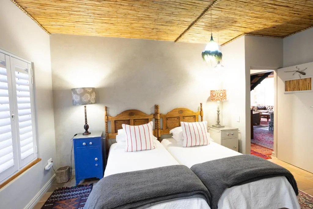 Bright bedroom with wooden bed frame and striped pillows, blue nightstand