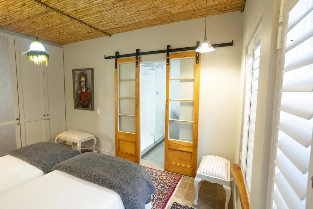 Bright bedroom with two beds, sliding barn doors, and natural light