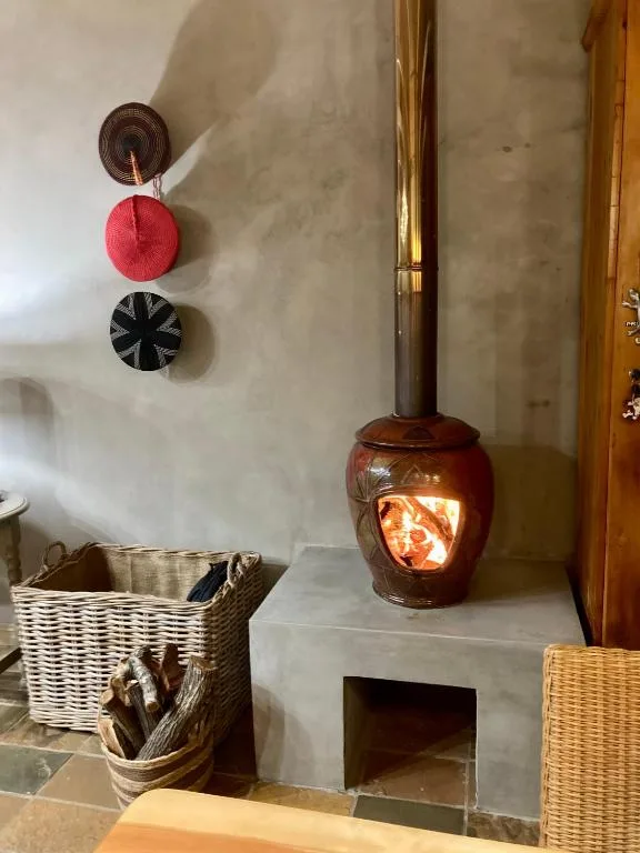Wooden stove with glowing fire and decorative wall baskets