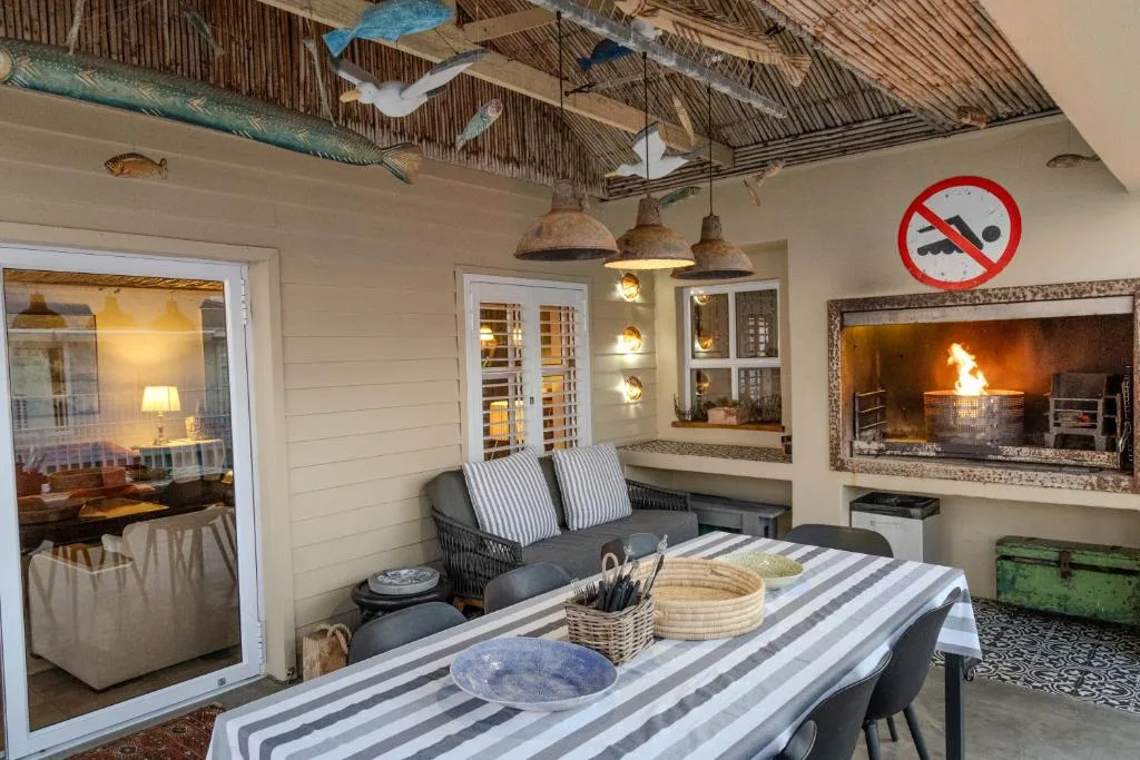 Indoor entertaining space with fireplace, dining table, and nautical decor elements