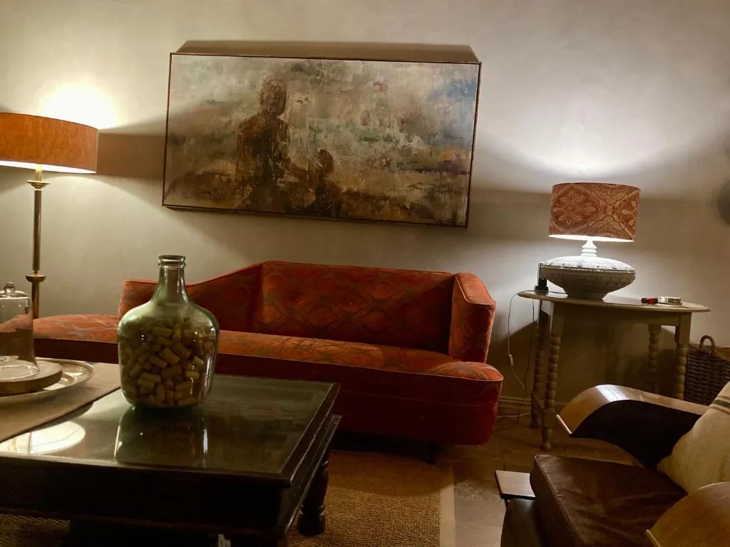 Modern lounge with rust-colored sofa, artwork, and warm lighting