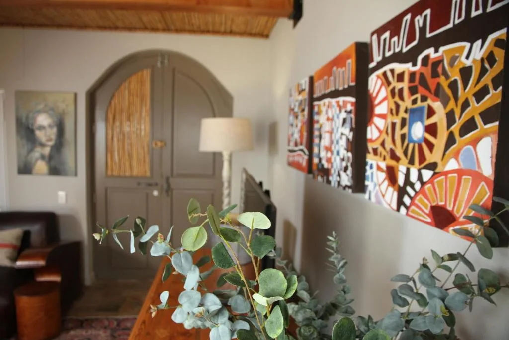 Modern living room with arched doorway, contemporary artwork, and potted plants