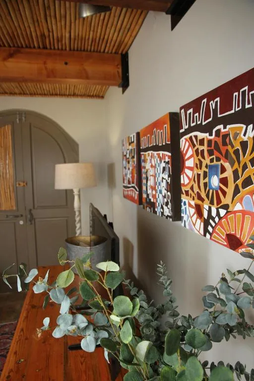 Modern lounge interior with wooden beams, colorful artwork, and potted plants