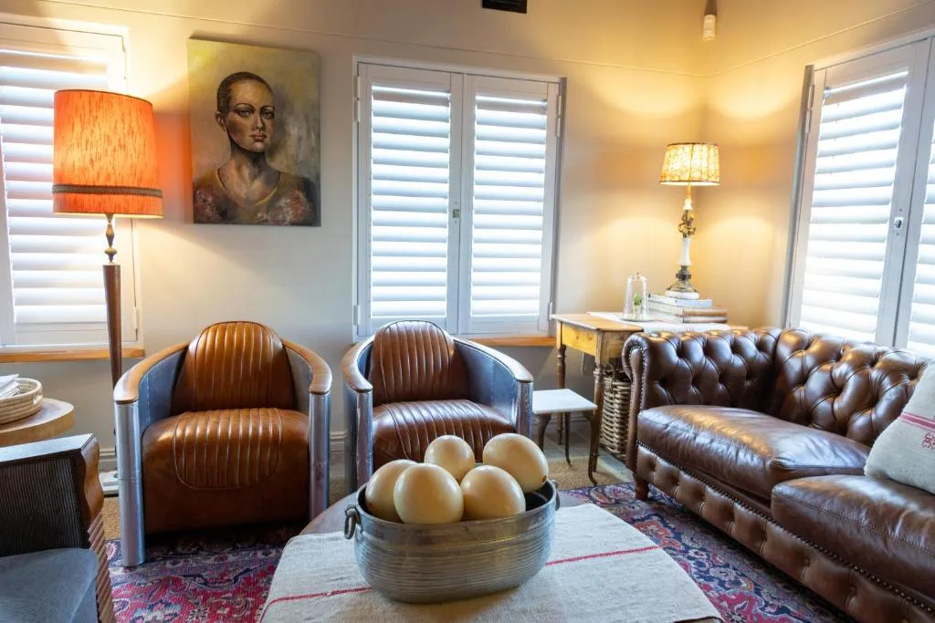 Elegant lounge with leather chairs, sofa, and warm lighting throughout