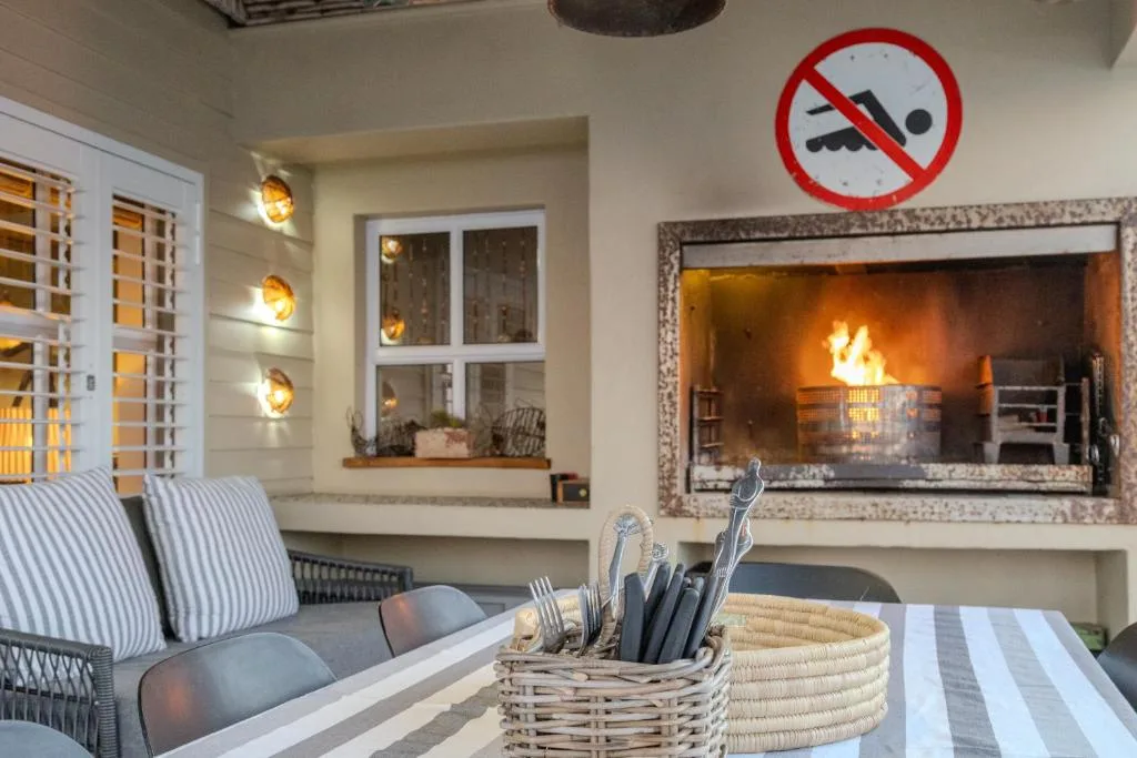 Cozy lounge with fireplace, striped armchairs, and warm lighting