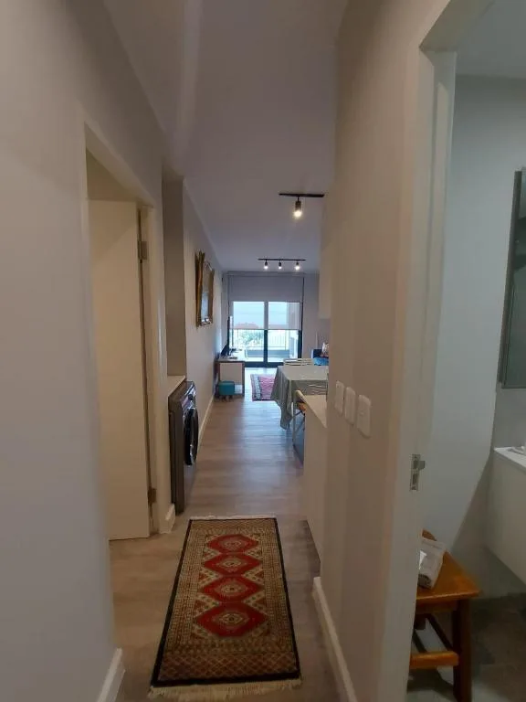 Modern hallway with wooden floors, cream walls, and geometric runner rug