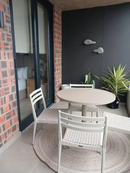 Modern outdoor patio with white round table and chairs, potted plants
