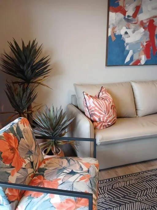 Cream sofa with decorative cushions in modern living room with plants