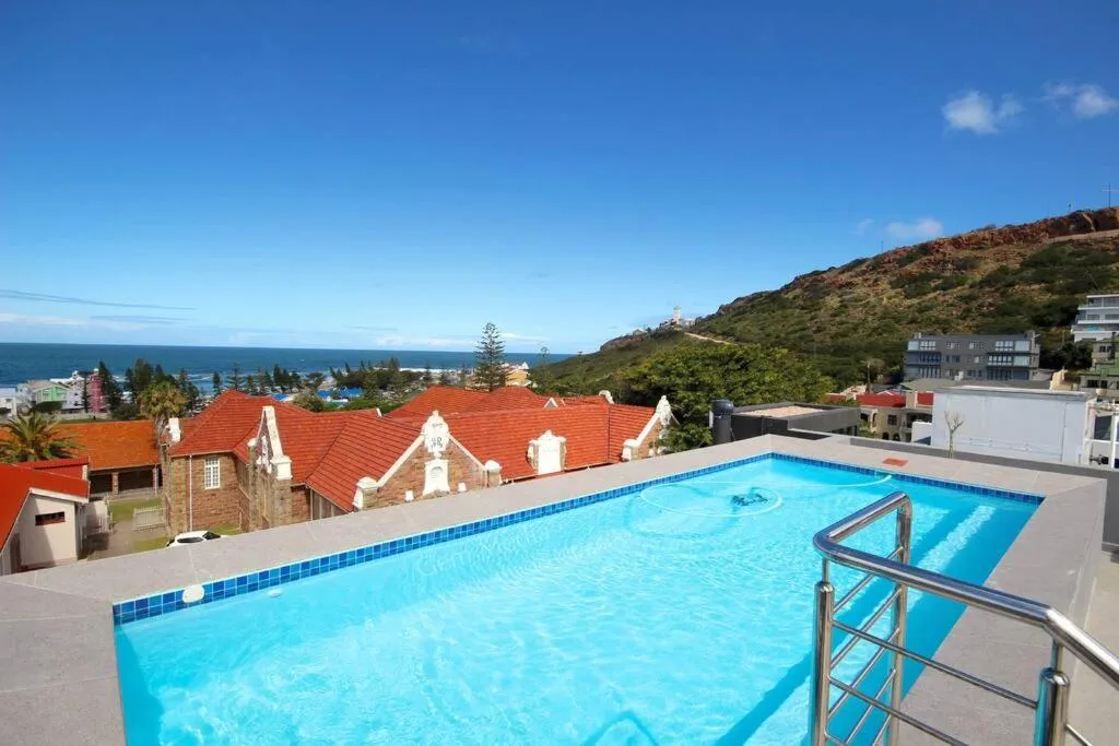 Sparkling blue swimming pool overlooking Mossel Bay and distant ocean horizon