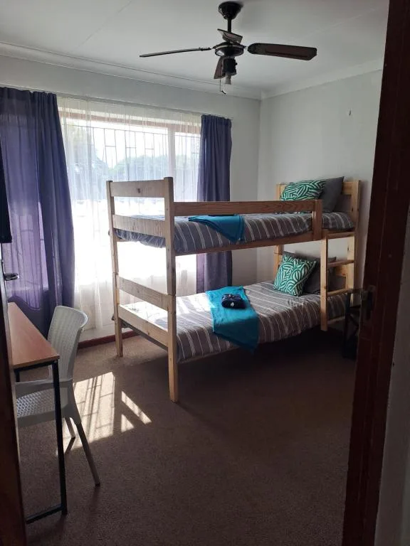 Bright bedroom with wooden bunk beds and blue accents throughout
