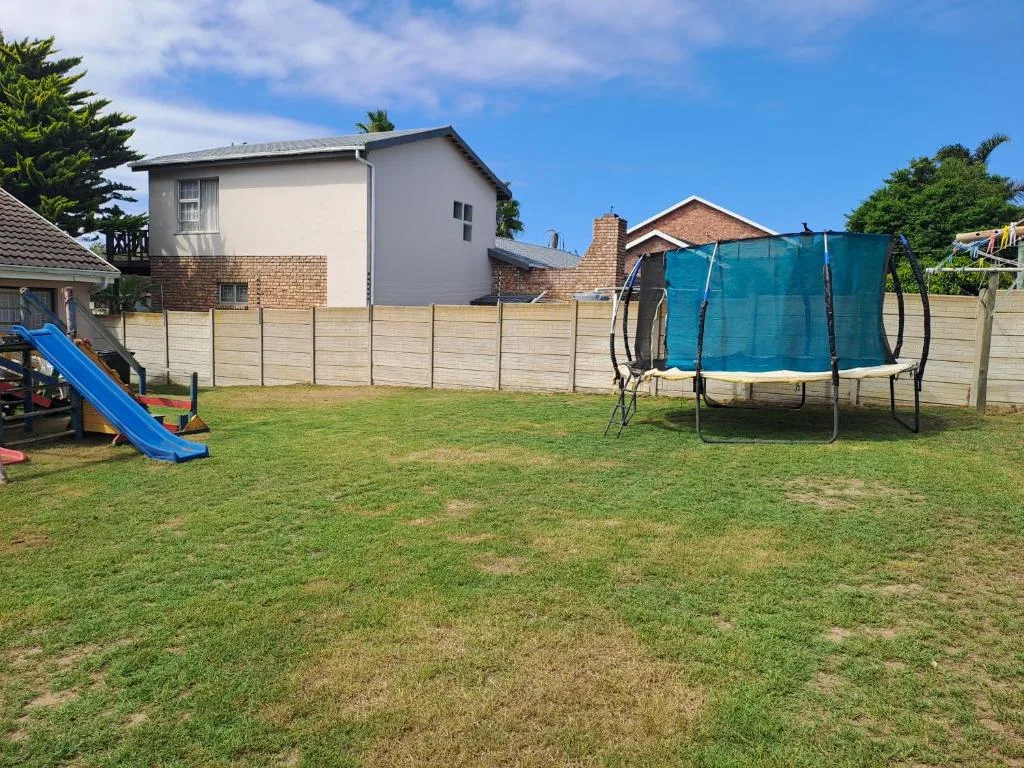 Two-story house with fenced garden, trampoline and children's play equipment
