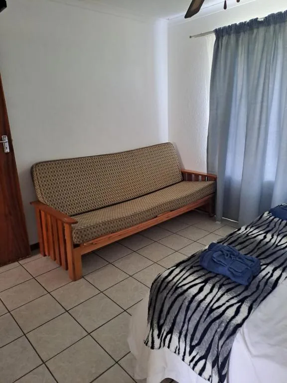 Spacious lounge area with wooden futon sofa and light curtains