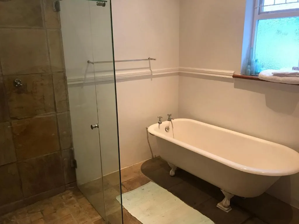 Spacious bathroom with freestanding bathtub and glass shower enclosure