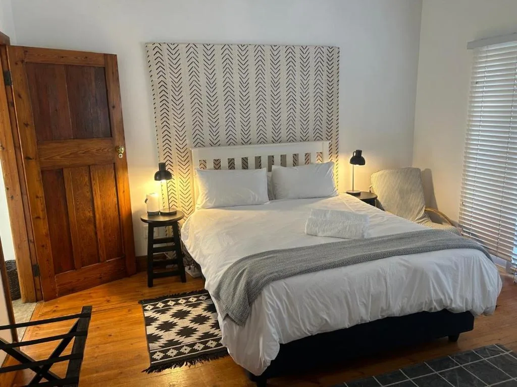 Modern bedroom with queen bed, patterned headboard, and contemporary lighting fixtures
