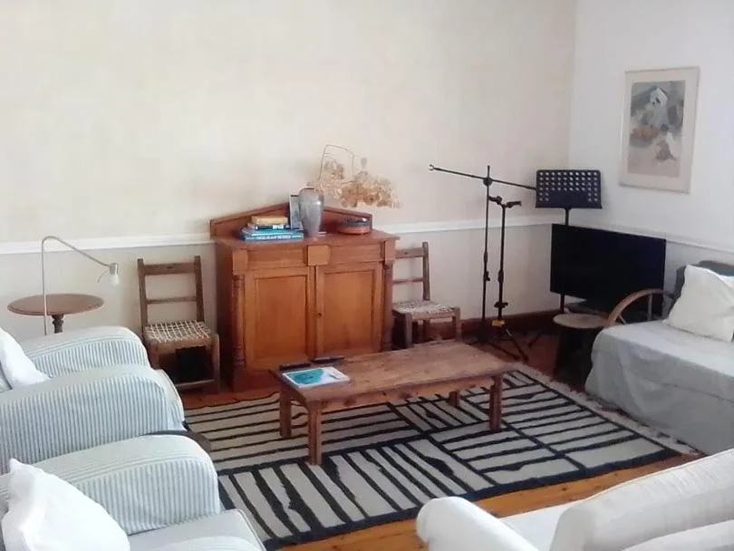 Spacious bedroom with multiple beds, wooden furniture, and entertainment setup