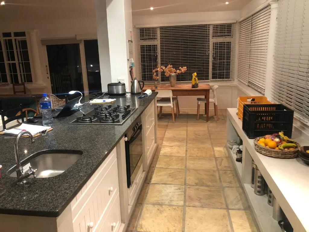 Modern kitchen with granite counters, gas stove, and dining area visible beyond