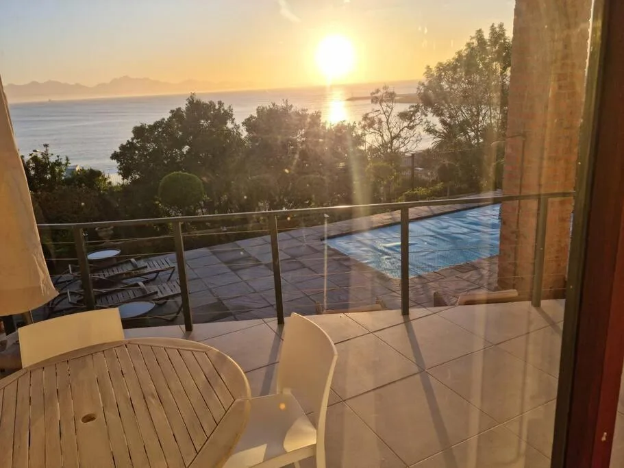 Sunset view from terrace with pool and ocean beyond