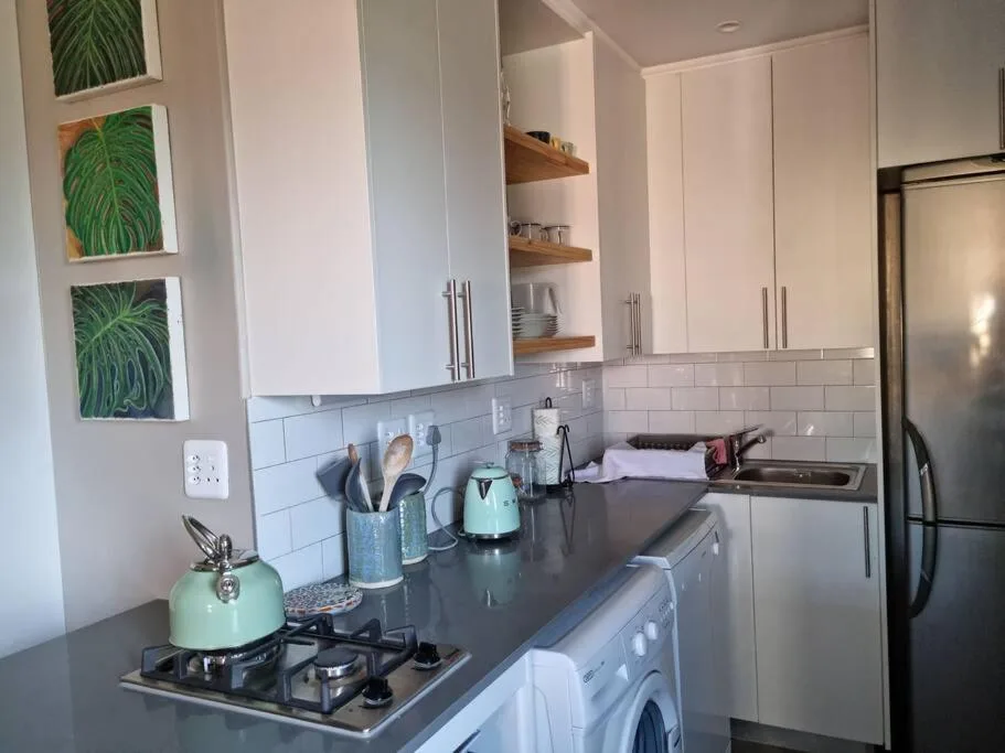 Modern kitchen with gas stove, stainless steel appliances, white cabinetry