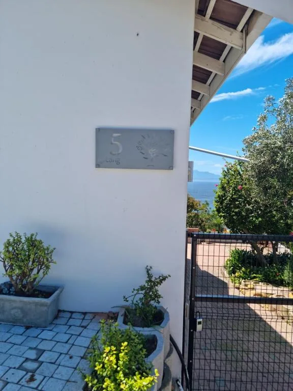 Ocean and mountain vista visible from property entrance with blue sky
