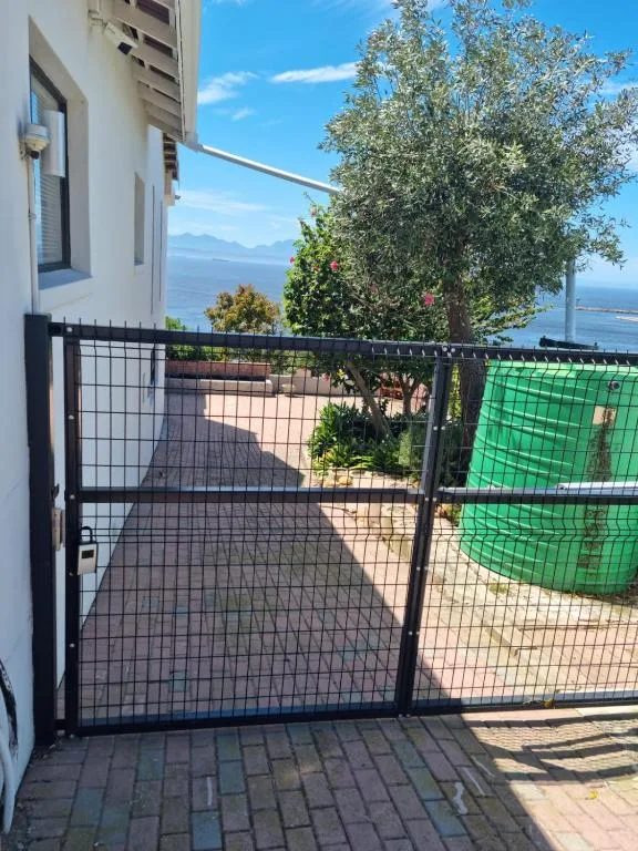 Ocean and mountain vista from gated deck area with garden surroundings
