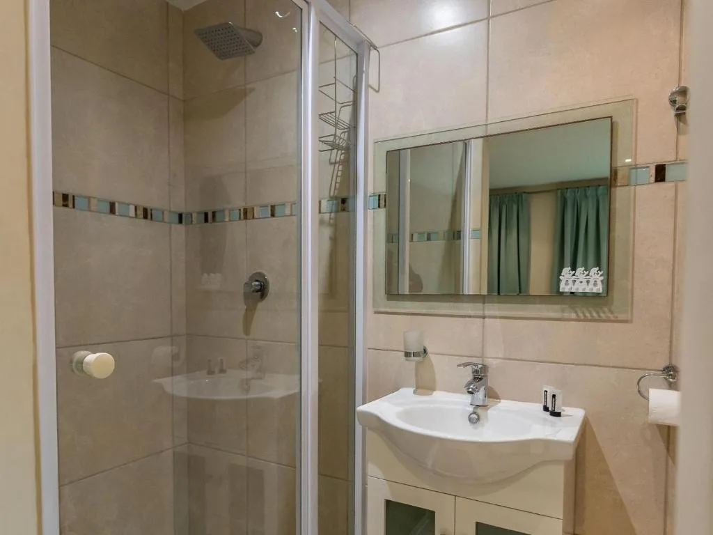 Modern bathroom with walk-in shower, vanity sink, and framed mirror